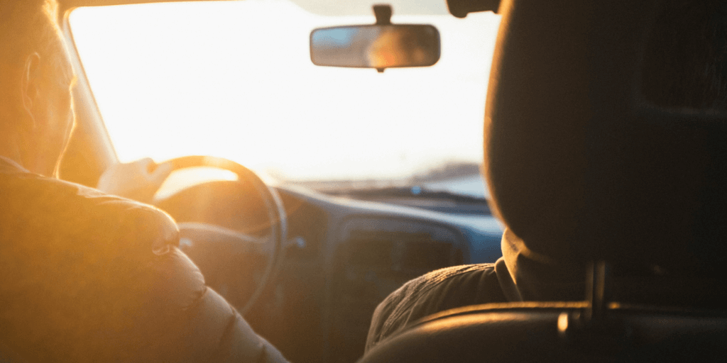 Achteraanzicht van een persoon die een auto bestuurt.