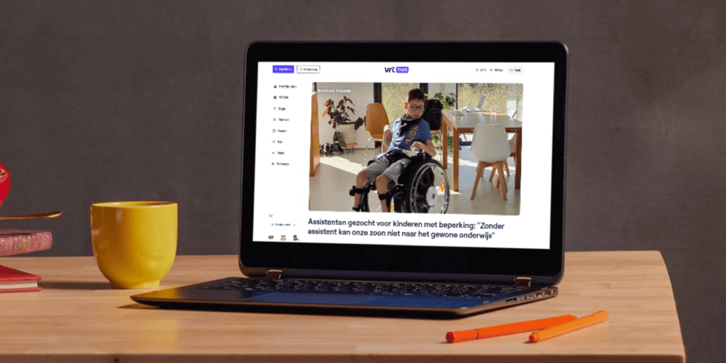 Laptop staat op tafel. Op het scherm staat een artikel van VRT NWS open: 'Assistenten gezocht voor kinderen met beperking: "Zonder assistent kan onze zoon niet naar het gewone onderwijs."'